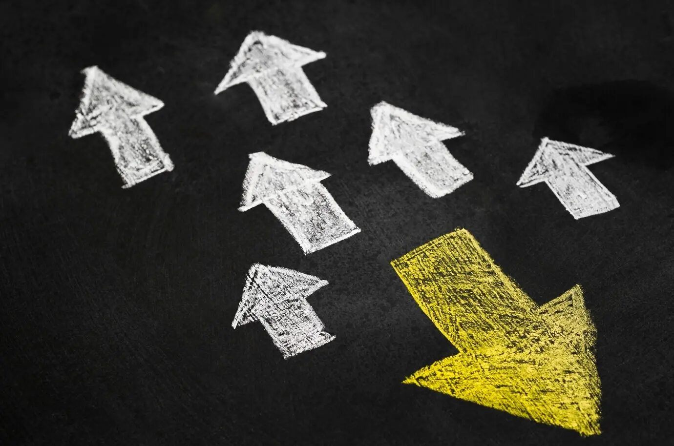 Жёлтая стрелка в группе белых стрелок, направленных в разные стороны.